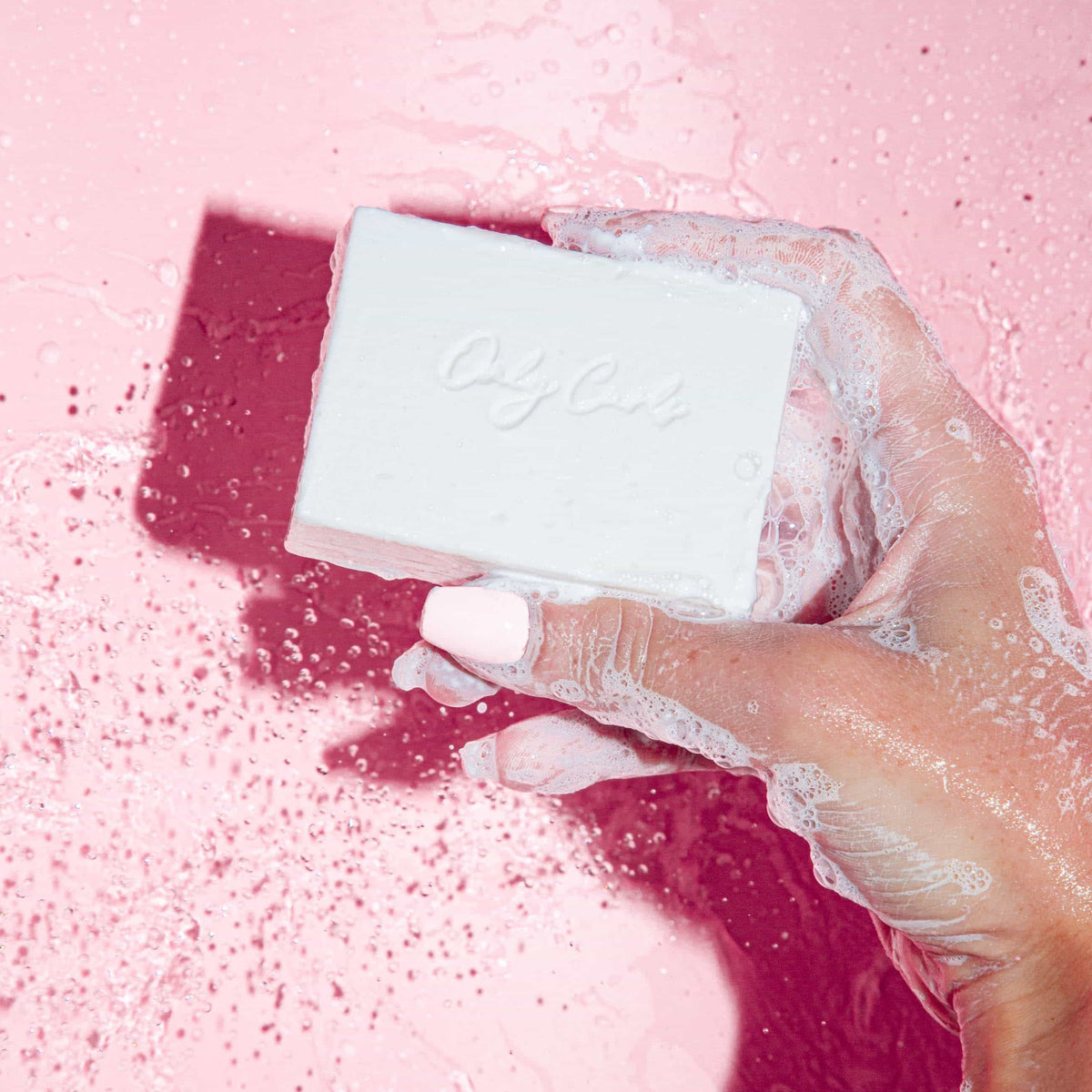 Only Curls holding the shampoo bar in the shower